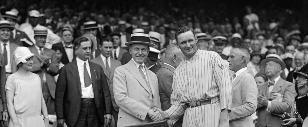 US President Calvin Coolidge (left) and Washington Senators pitcher Walter Johnson (right) shake hands.